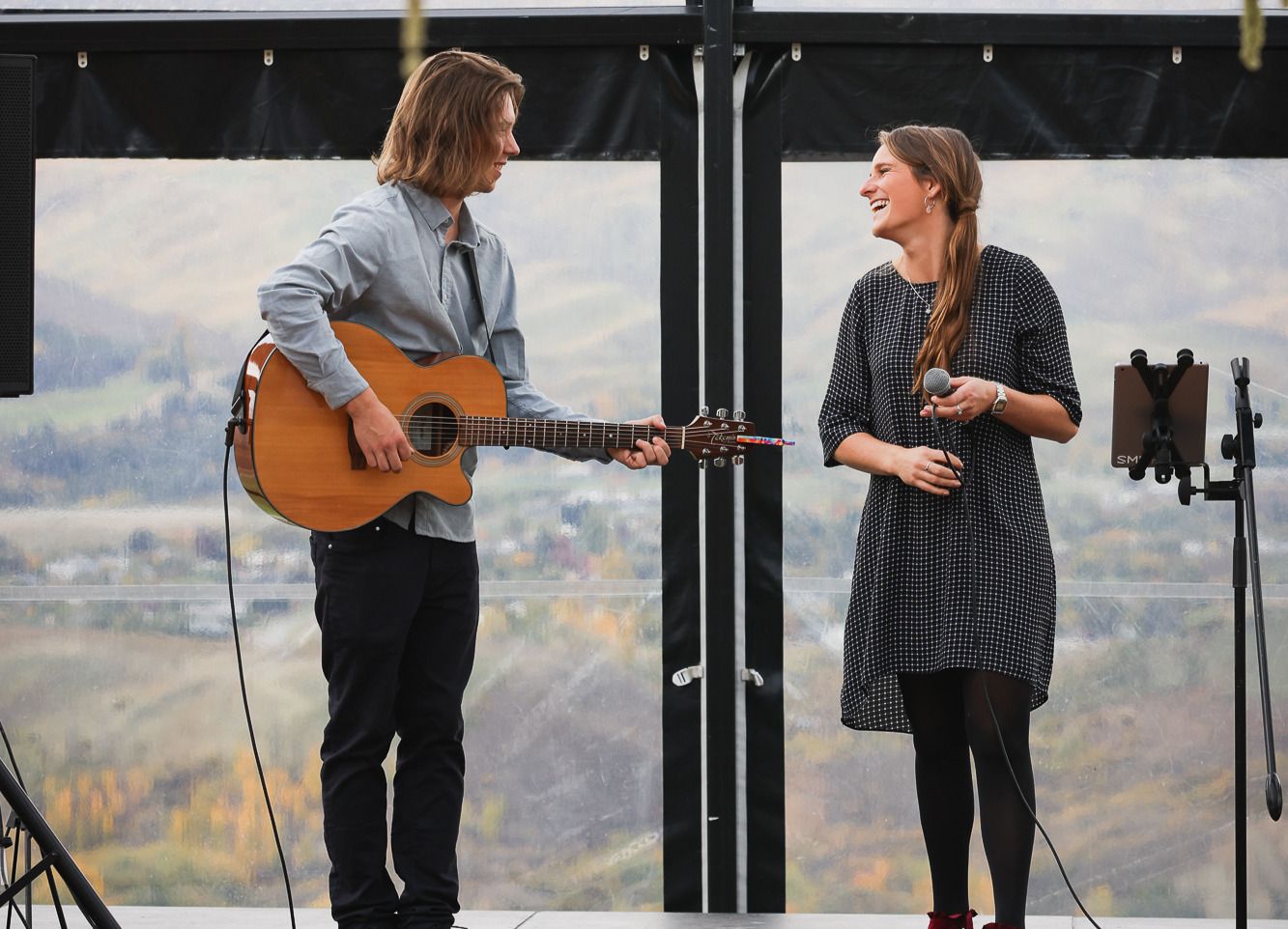 Elle and Alex performing with a mountain view behind them