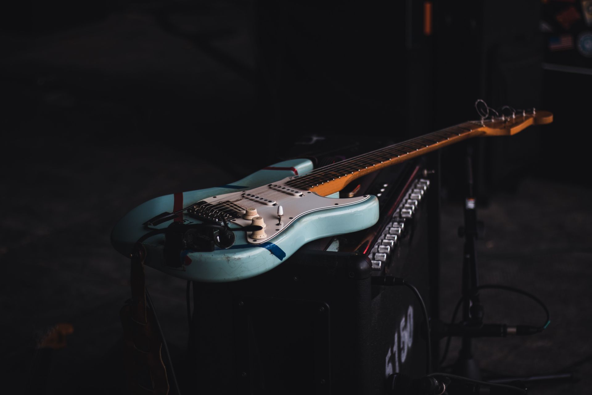 An electric guitar resting on an amp
